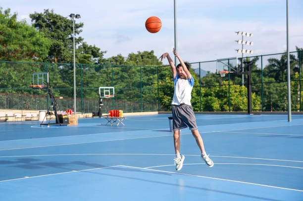 Cute Asian boy playing basketball