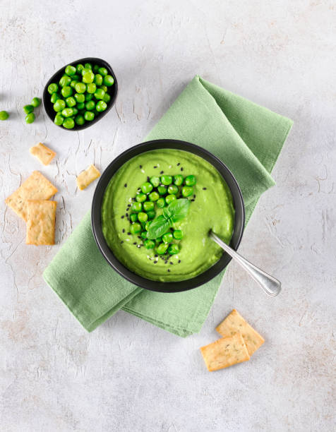 istock Green pea cream soup with crackers on a gray table. Top view. 2169885891