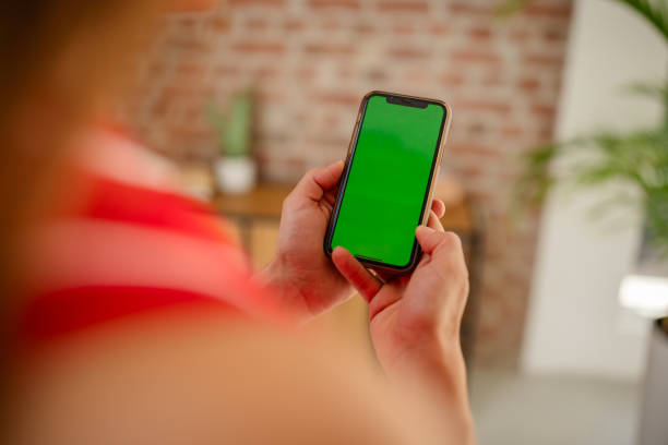 istock Person holding smartphone with green screen indoors 2169887601