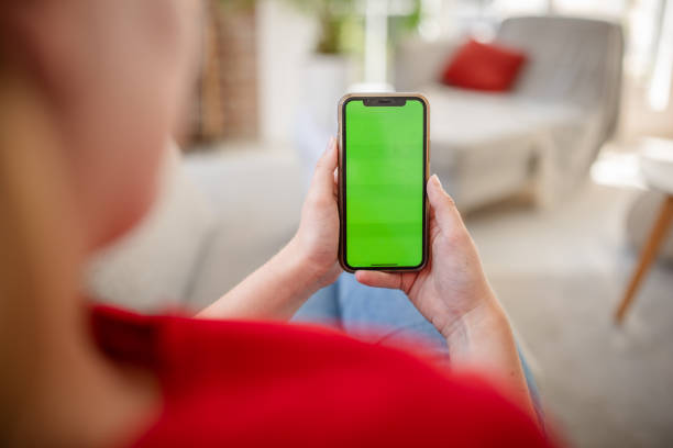istock Person with smartphone sitting on couch in cozy space 2169888095