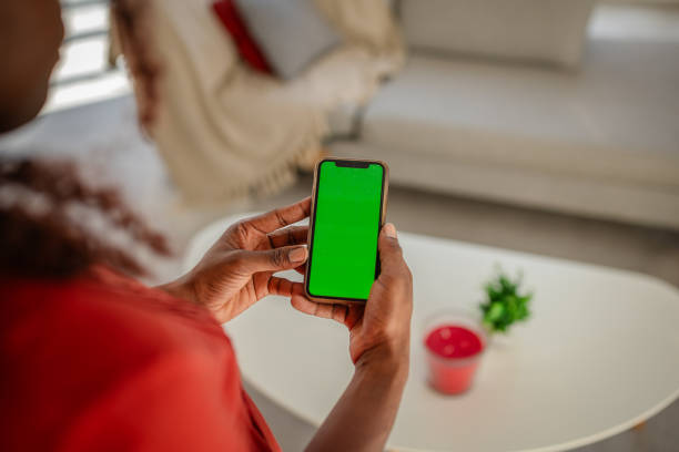 istock Smartphone With Green Screen Held In Hands Over Table 2169888502