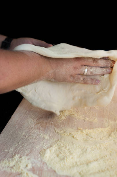 istock baker's hands knead the dough for baking pizza 2169892767