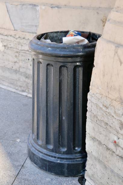 istock public trash can on city street filled with garbage. plastic waste in trash can container. 2169898268