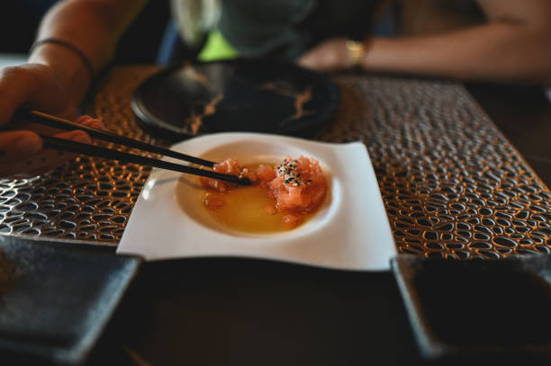 Eating salmon tartar in a restaurant.