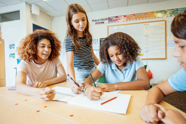 istock A group of diverse junior high students and teacher collaborating and working on an assignment together at a classroom desk in an educational setting. 2169899754