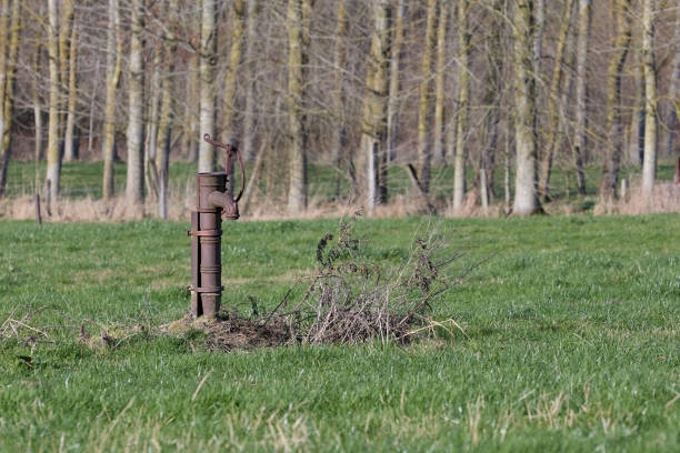 Vintage metal water pump on meadow