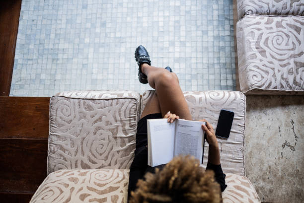 Young woman reading book at home