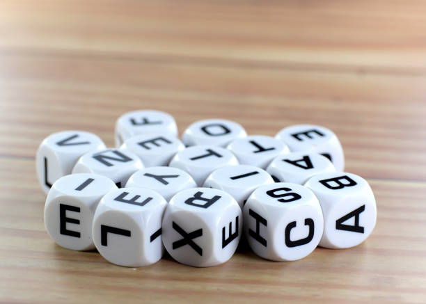 many white letter dice with brown background.