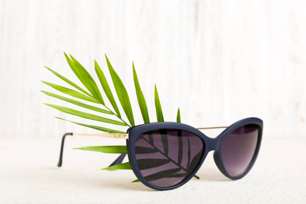 istock sunglasses with seashell lying on table background. Sunglasses on summer background. Top view flat lay with copy space for text 2169903455