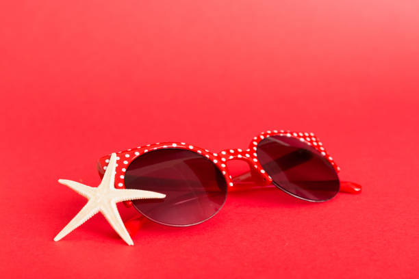 sunglasses with seashell lying on table background. Sunglasses on summer background. Top view flat lay with copy space for text.