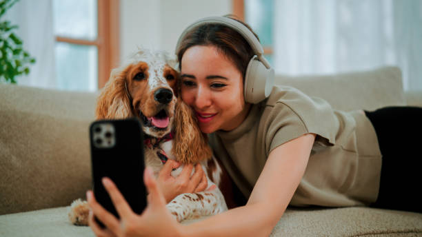 istock Young pet owner taking selfie while playing with her dog at home. 2169905275