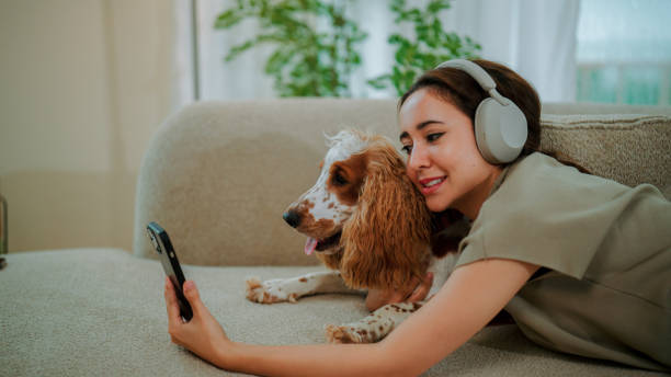 istock Young pet owner taking selfie while playing with her dog at home. 2169905277
