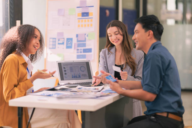 istock A team of UI UX web designers are working together to develop a mobile responsive website while discussing a project at a modern conference table. Brainstorming 2169906412