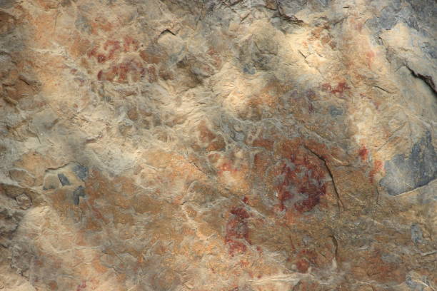 Ancient stone walls, brown and very old, with painted patterns on the surface.