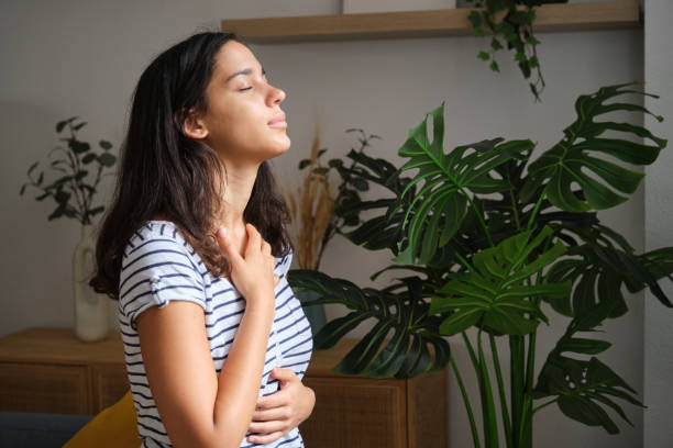 Young woman practicing deep breathing exercise at home