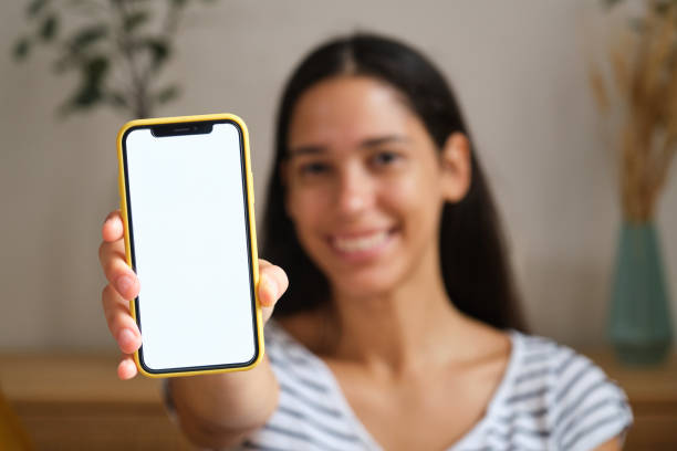 istock Woman holding smartphone with white screen at home 2169909393