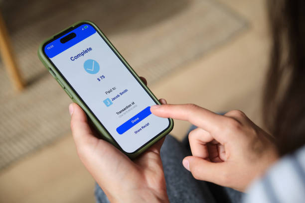istock Woman completing mobile payment on smartphone at home 2169909513