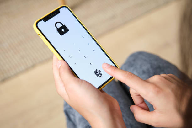 Woman unlocking smartphone using fingerprint scanner for mobile payment