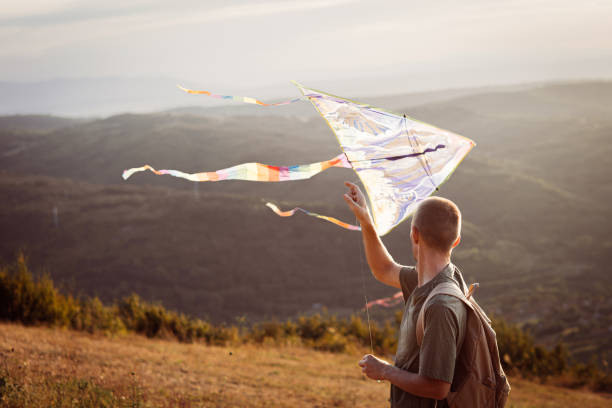 istock Happy man is playing with kite on sunny day. 2169911036