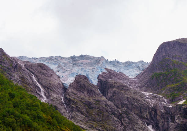 Supphellebreen, a stunning Norwegian glacier nestled among rugged mountains and lush forests, showcasing nature's raw and serene beauty.