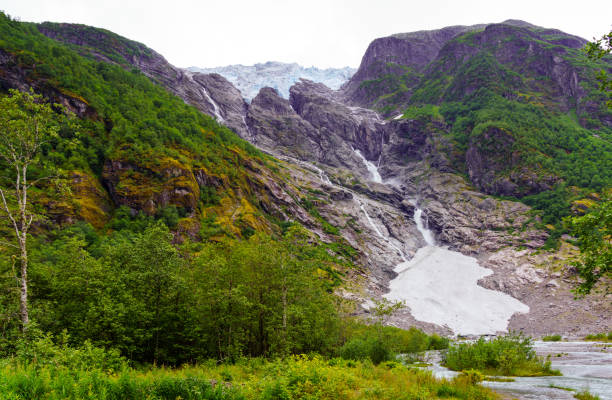Supphellebreen, a stunning Norwegian glacier nestled among rugged mountains and lush forests, showcasing nature's raw and serene beauty.