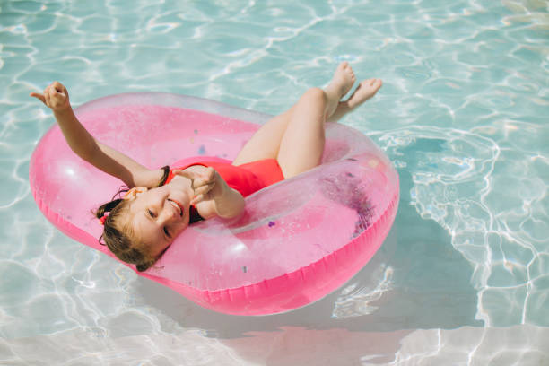 istock Little Girl Relaxing on Inflatable Ring in Pool 2169915708