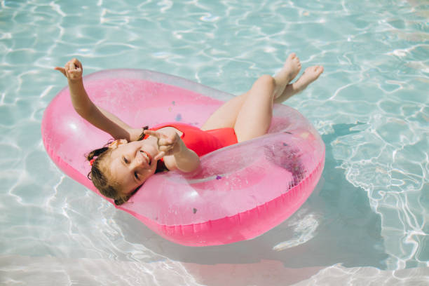 istock Little Girl Relaxing on Inflatable Ring in Pool 2169915712
