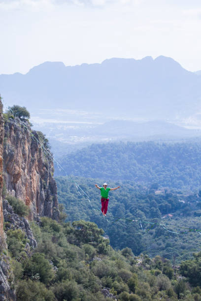 istock A tightrope walker walks along a cable stretched over a canyon. 2169917045