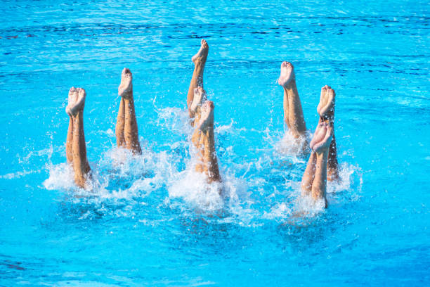 istock Synchronized swimming team performing artistic swimming choreographed legs movement in the water. Water ballet. 2169918628