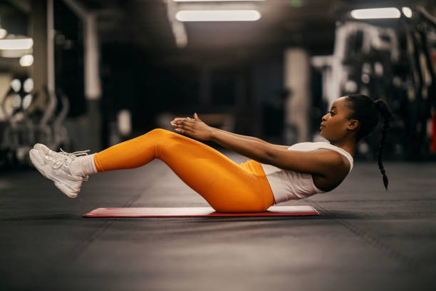 istock A young fit black sportswoman in shape is practicing crunches at gym. 2169920651