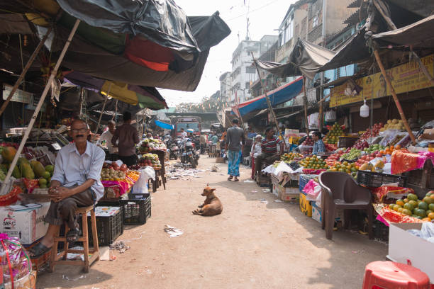 Mysore, India - February 16, 2017: Traders of pineapples and tropical fruits talking with customers at street market on February 12 2017. With population 900,000, Mysore is the cultural capital of Karnataka