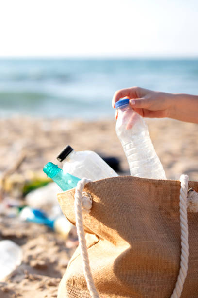 istock picking up plastic garbage on a beach. Plastic pollution and global ocean ecological and environment problems concept. 2169930600
