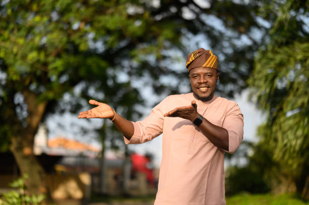 istock Smiling Nigerian man pointing to ad copy space with inviting demeanor. 2169937723