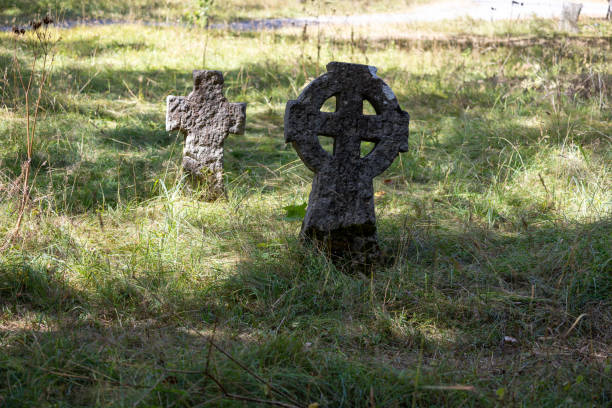 istock Ancient Stone Crosses in a Grassy Cemetery 2169941115