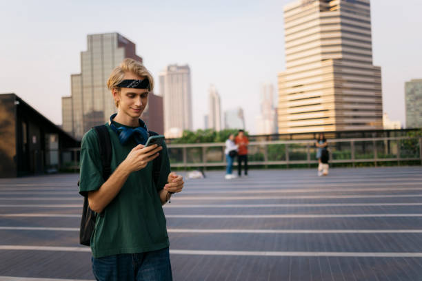 istock Young student surfing the net on smart phone while walking outside in the city 2169942134