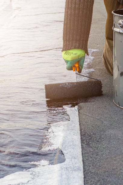istock a young worker treats a roof with bitumen primer before applying rolled asphalt roofing using a torch 2169943224