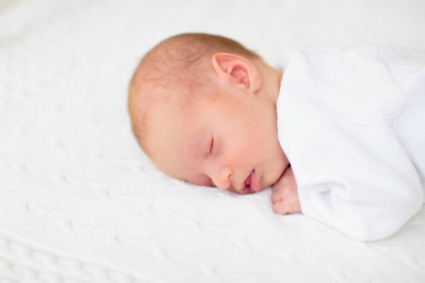istock Little baby on white bed 2169943887