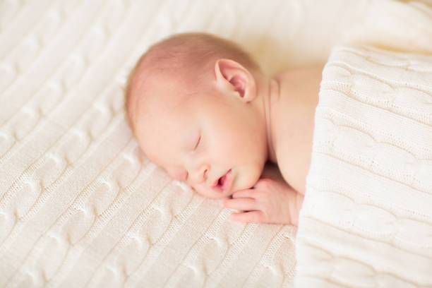 istock Little baby on white bed 2169944662