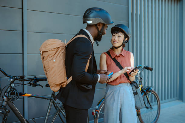 istock Business professionals using smartphones while wearing bike helmets 2169944873