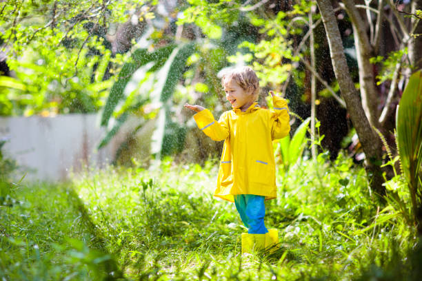 istock Child playing in the rain. Kid with umbrella. 2169944932