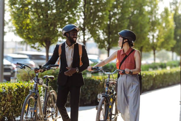 istock Two coworkers enjoying a walk with bicycles in urban setting after work 2169945043
