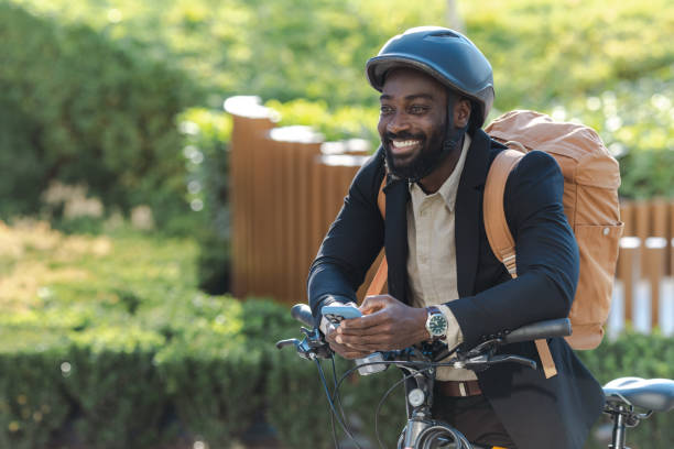 istock Smiling man commuting on bicycle with smartphone and backpack 2169945044