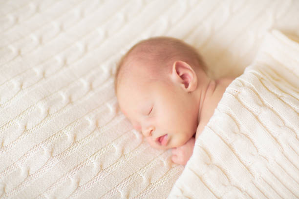 istock Little baby on white bed 2169945701