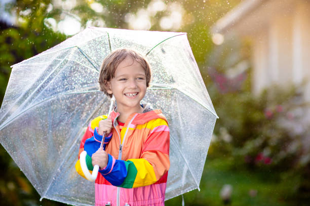 istock Child playing in autumn rain. Kid with umbrella. 2169945954