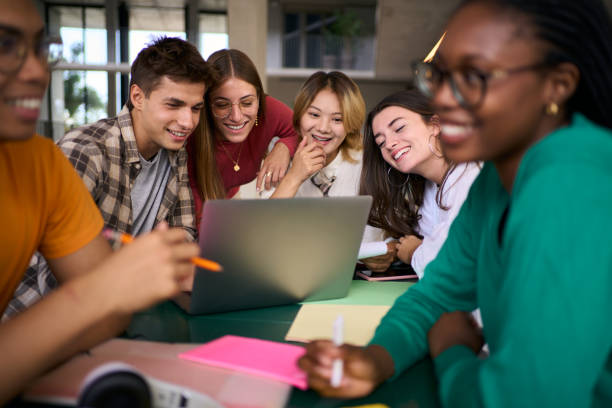 istock Group of young university students people gathered using laptop together in campus study hall. 2169949728