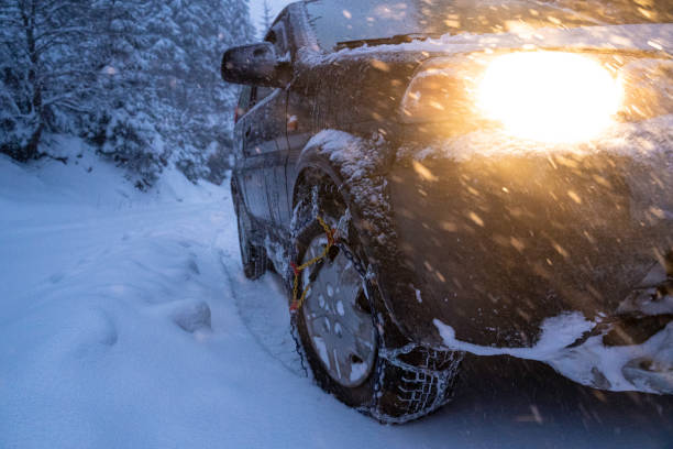 istock Snow Chains. Car Driving in Blizzard at Dusk. 2169952783