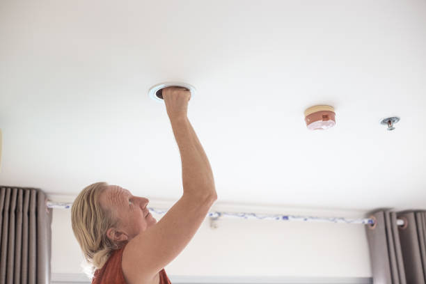 istock A man replaces an LED light bulb in a ceiling light 2169956543
