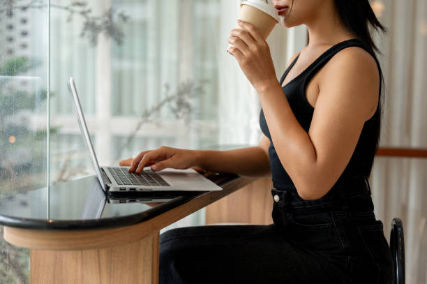 istock A woman enjoying coffee while working remotely from a modern, minimalist coffee shop. 2169960342
