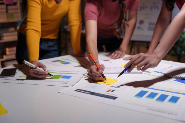 istock Team of marketing professionals are collaborating on a project, analyzing charts and graphs, and brainstorming ideas 2169965693