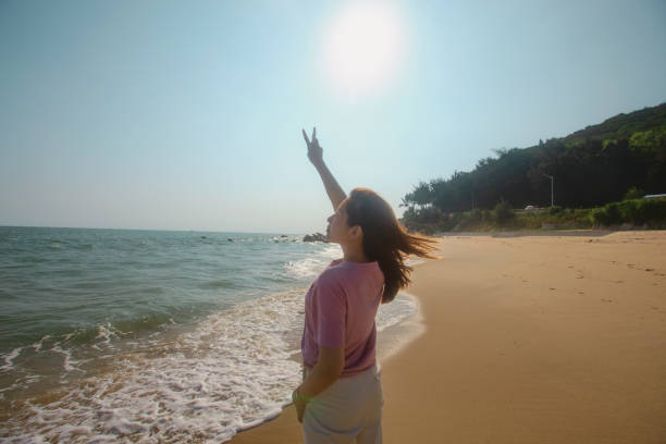 A lady is taking a walk on the beach to relax and unwind